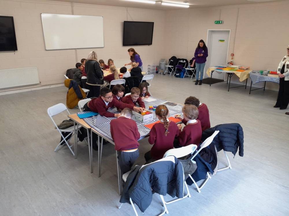 Schoolchildren sitting around a desk in a room